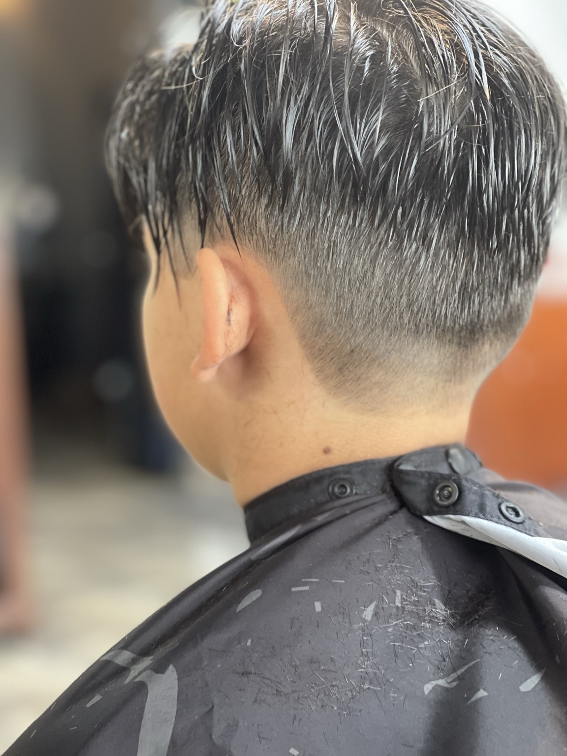 Low taper fade from back with longer wet top